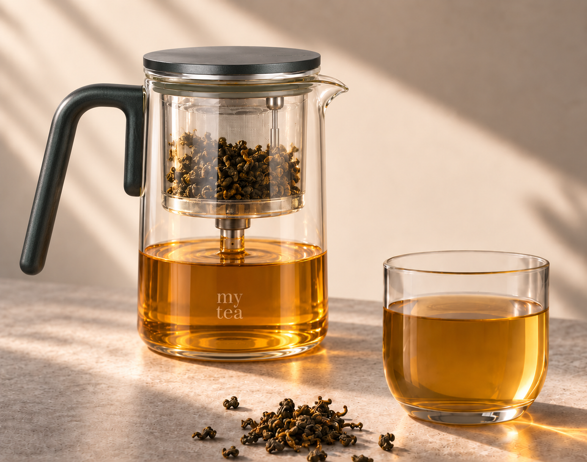 Glass teapot with amber tea and a glass cup